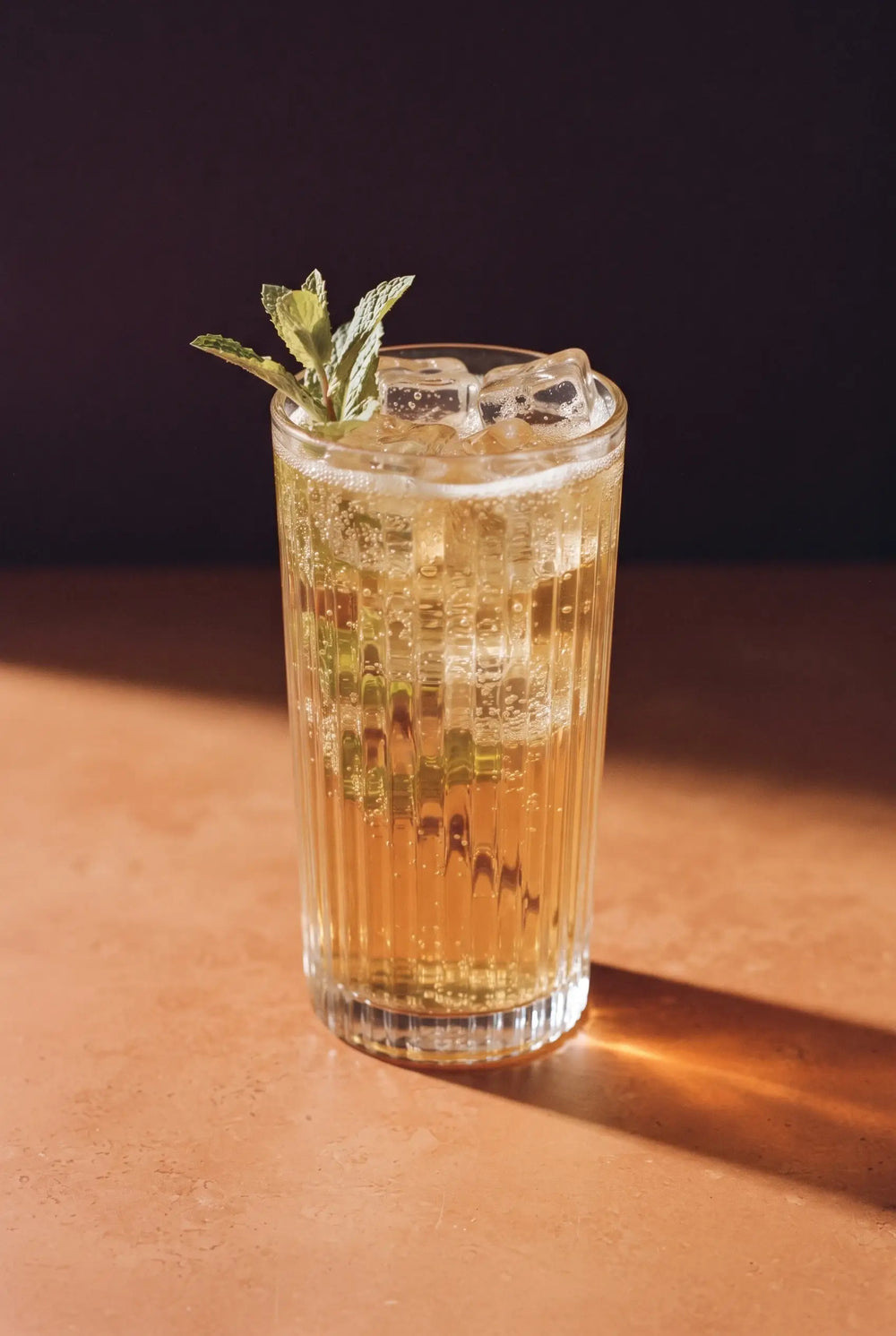 Kinn and Mint: a tall ribbed glass of Kinn over ice with a spray of fresh mint