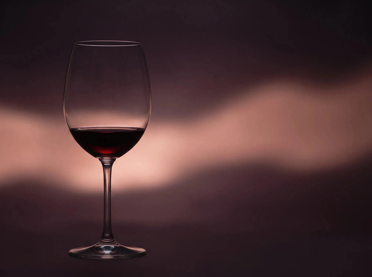 A glass of red wine against a dark background
